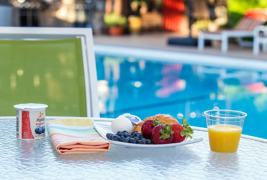 Continental breakfast items, with pool in background.